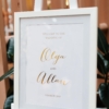 Gold foiled wedding welcome sign, set in a white frame with matching white timber easel. Image Gemma Clarke.